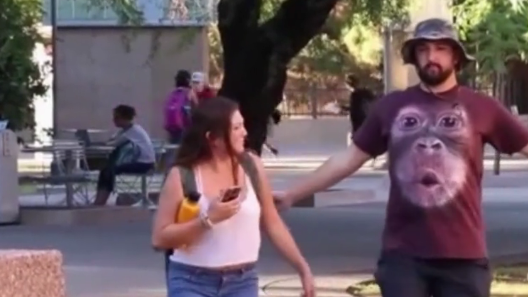 男子用搞怪的走路姿势走在路人身旁,路人被逗笑了!